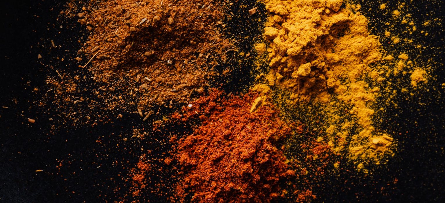 assorted colorful dry powdered spices on black background